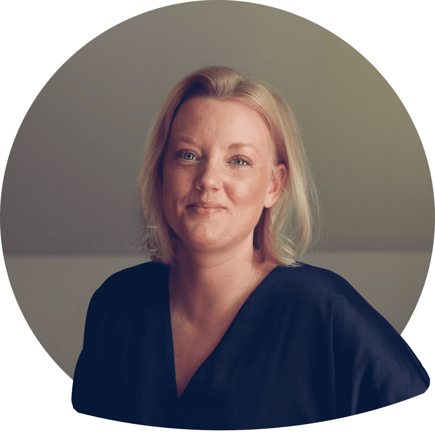 Anna smilende i blond skulderlangt hår i lys skjortebluse. Foto.