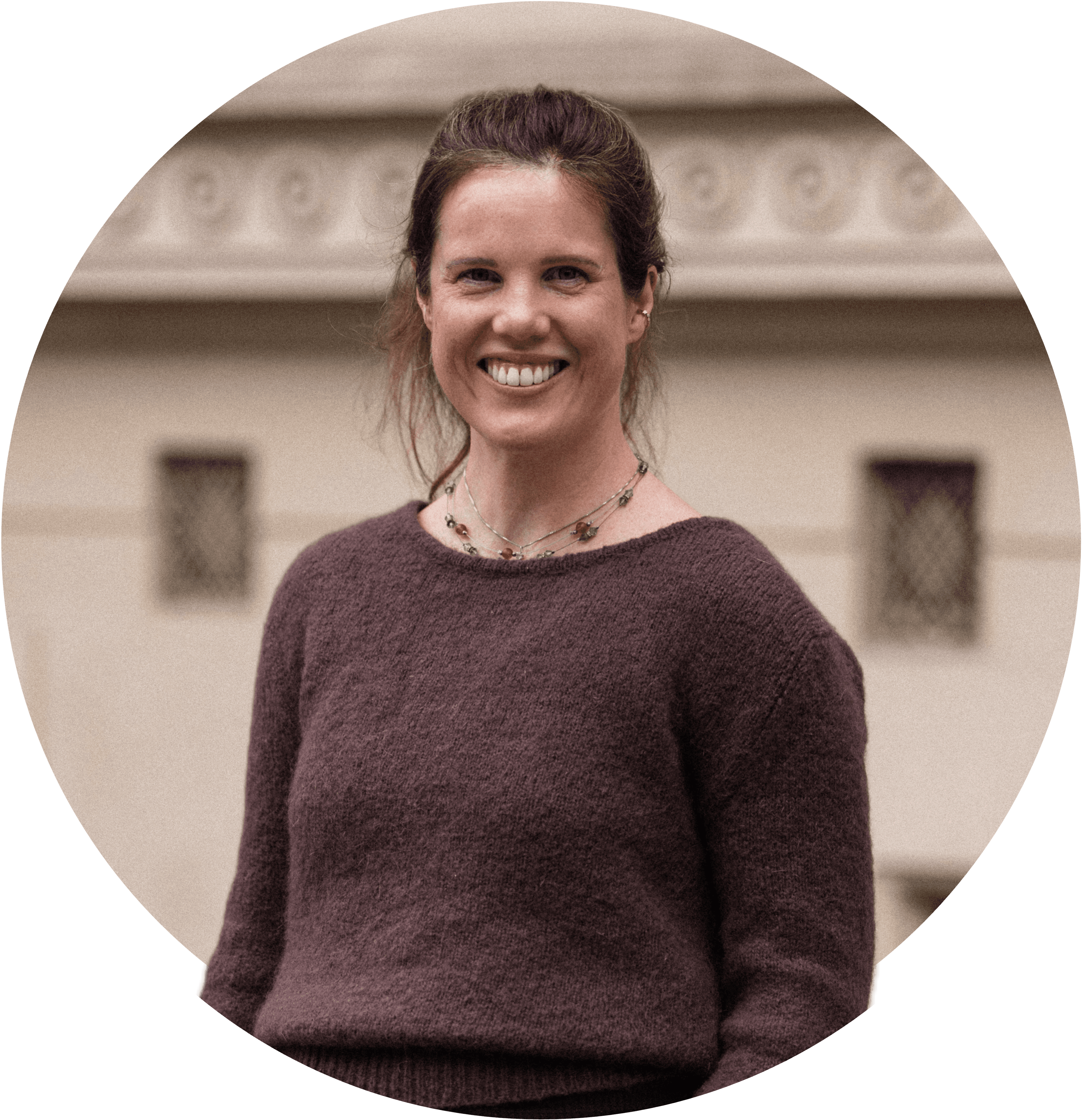 Linn smiler, iført en brun trøje og med håret i hestehale. Foto.