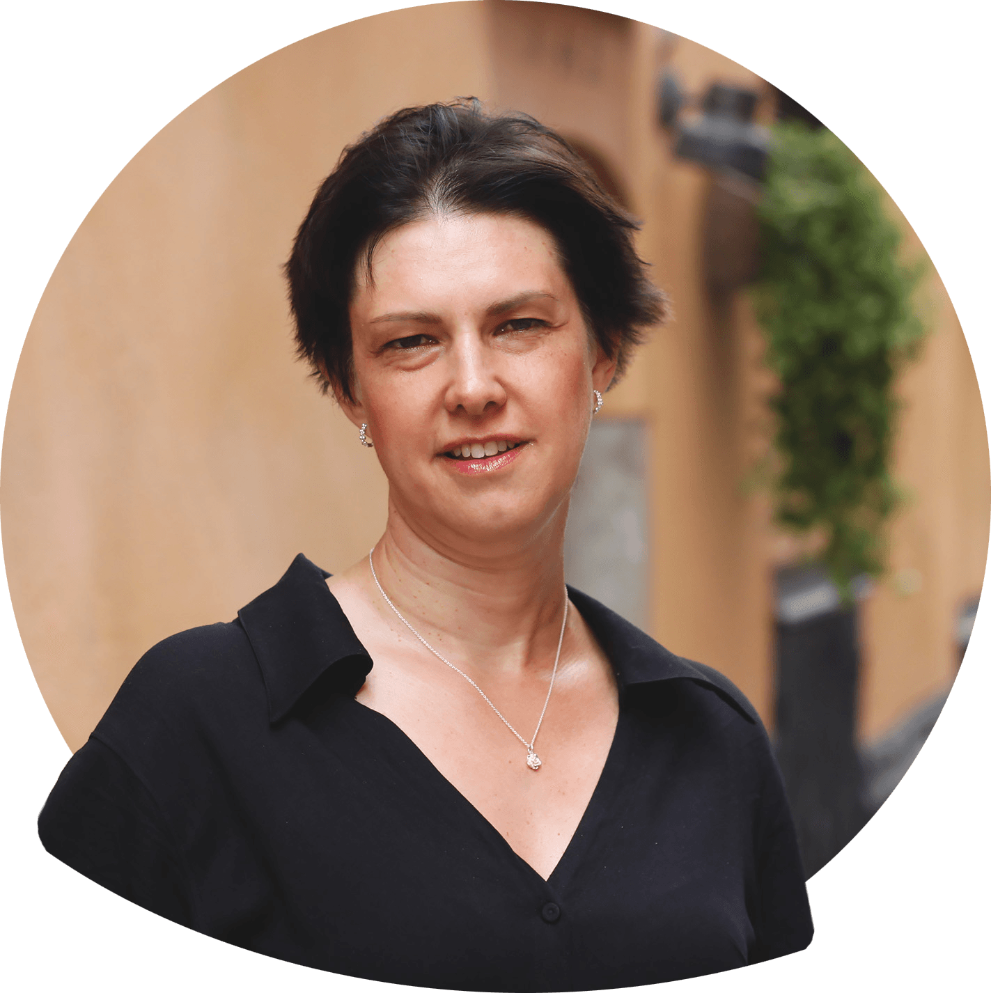 Sandra smilende med rødbrun kortere frisure. Foto.