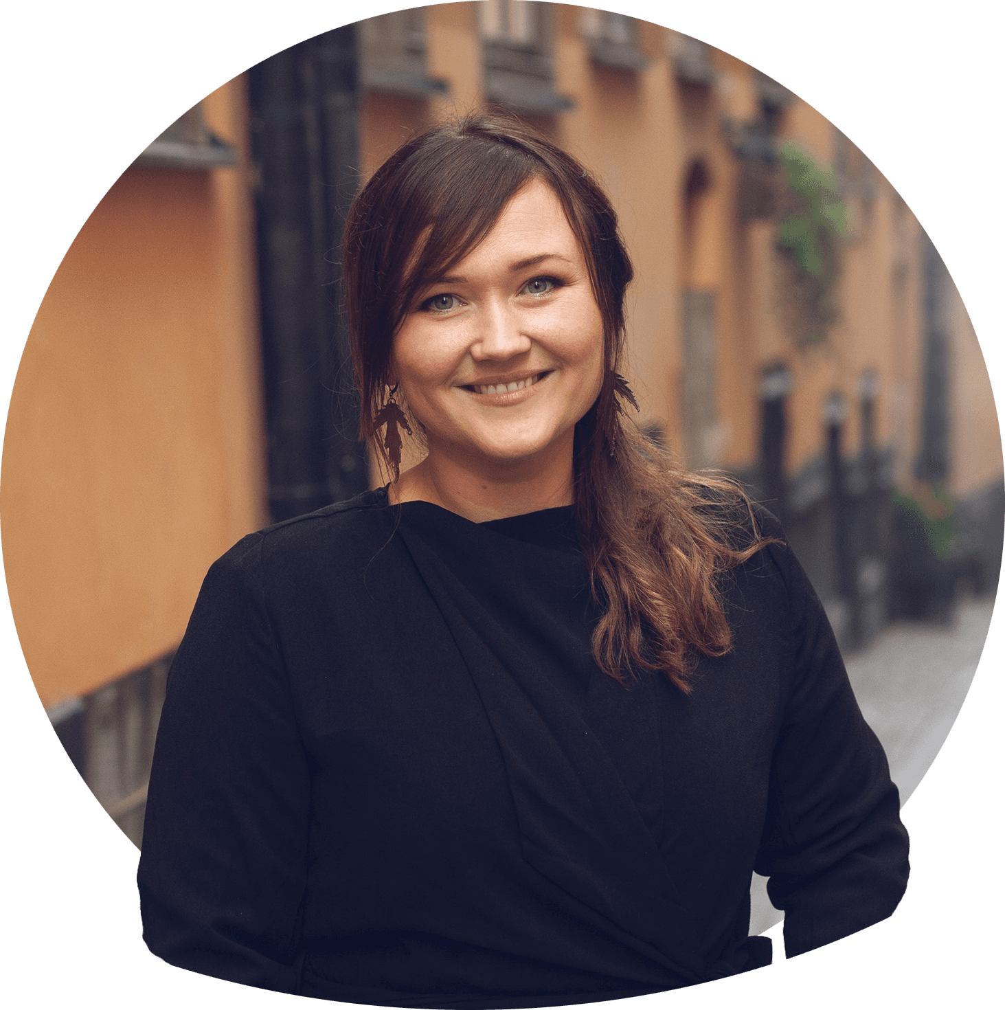 Moa smilende med skulderlangt sort hår, sort trøje over hvid bluse med krave. Foto.