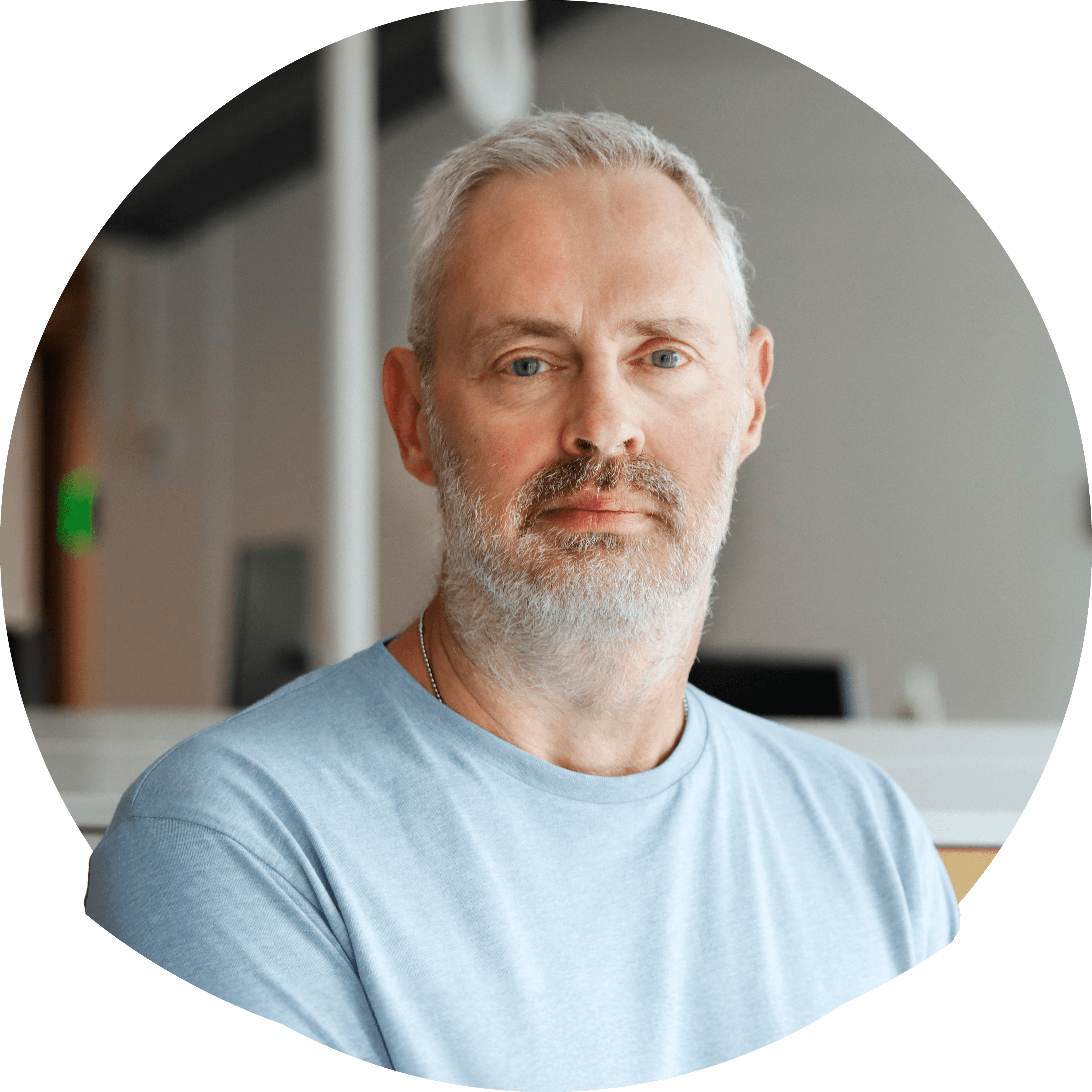 Tommy O smilende med kort sølvfarvet hår i olivengrøn t-shirt. Foto.